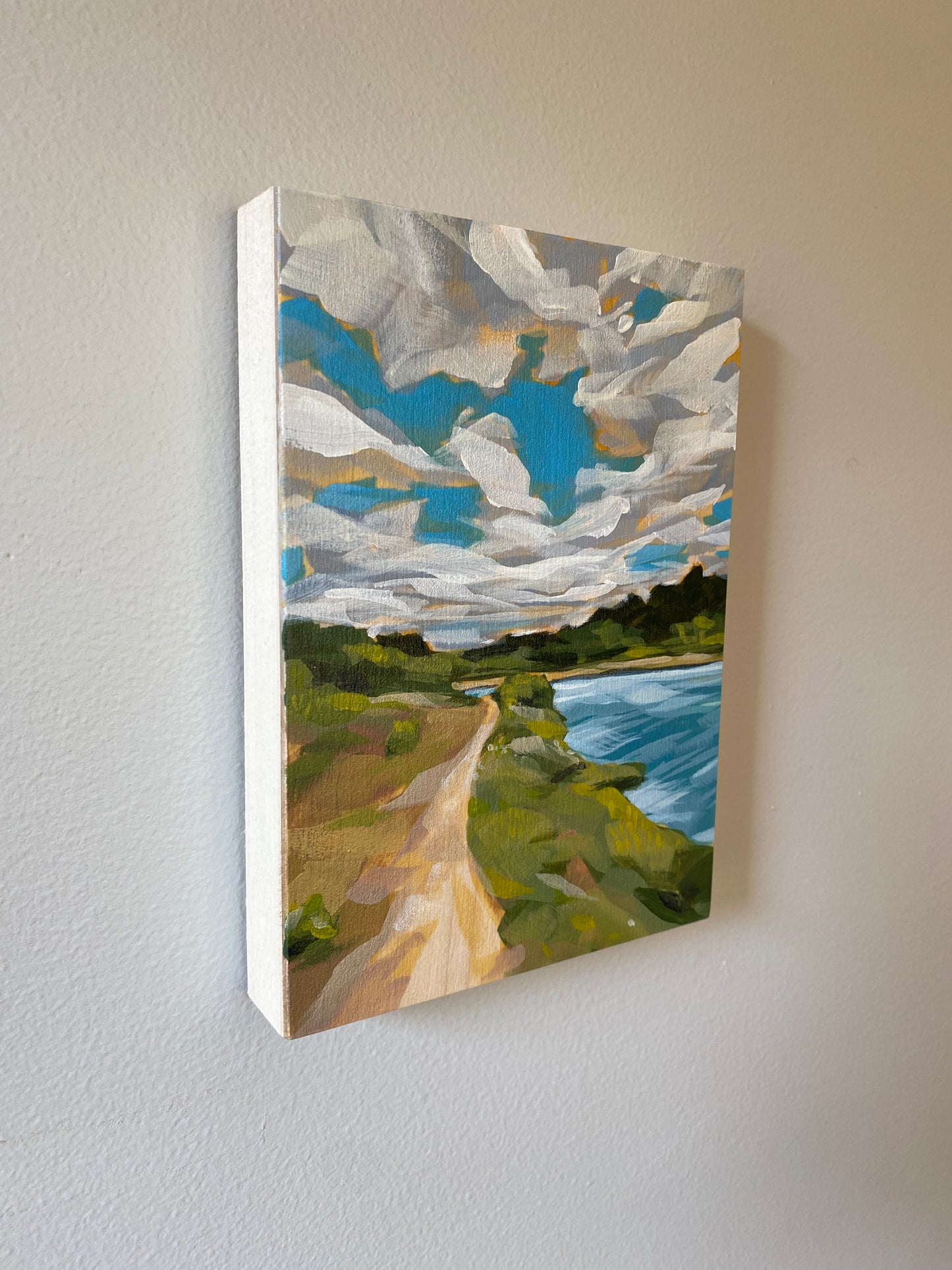 5x7 acrylic painting for sale of a trail . Features bright blues with a cloudy sky and lush green trees.