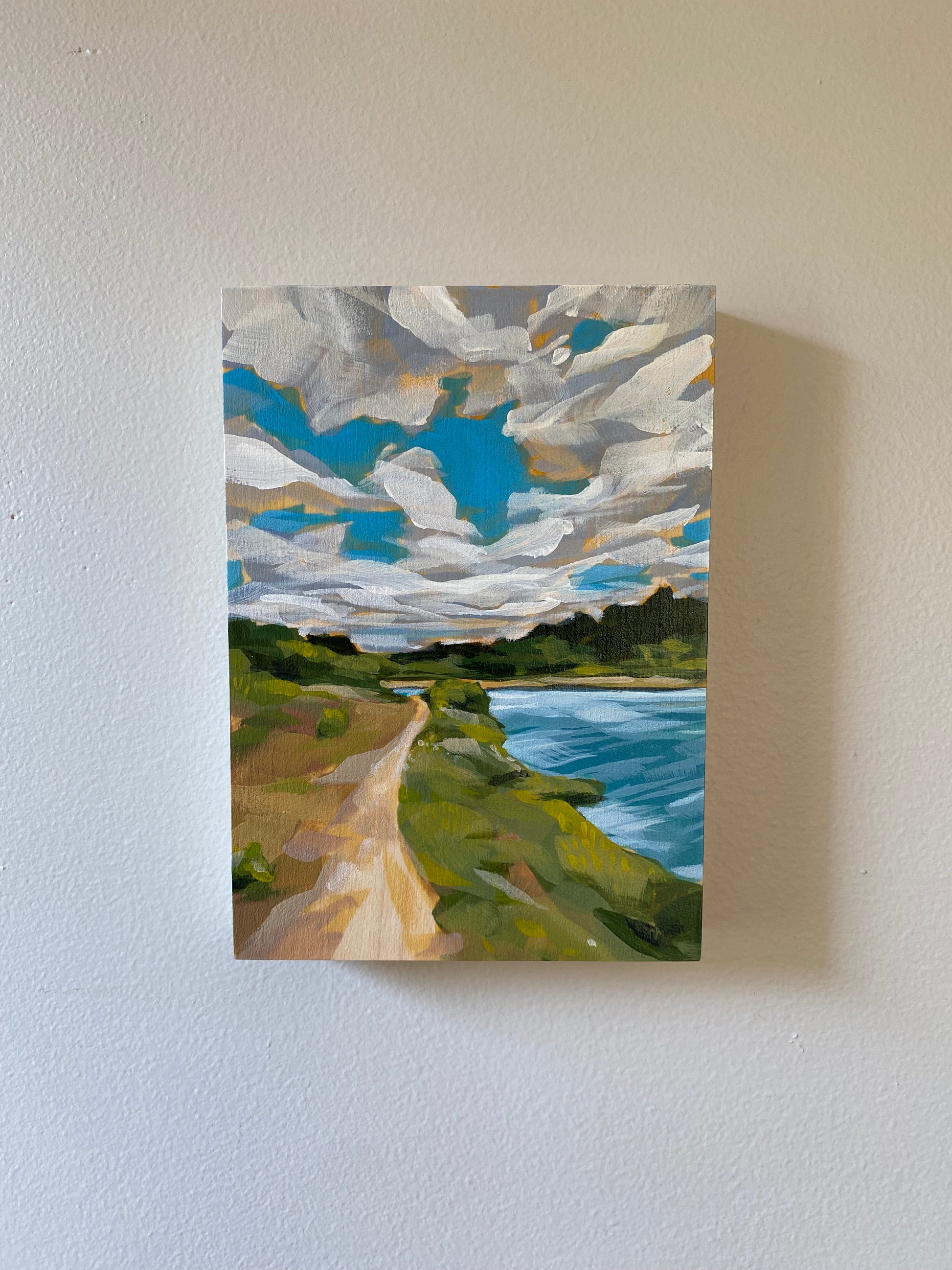 5x7 acrylic painting for sale of a trail . Features bright blues with a cloudy sky and lush green trees.